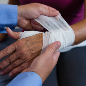 caregiver bandaging hand of patient
