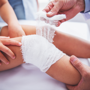 young child getting bandage wound on leg