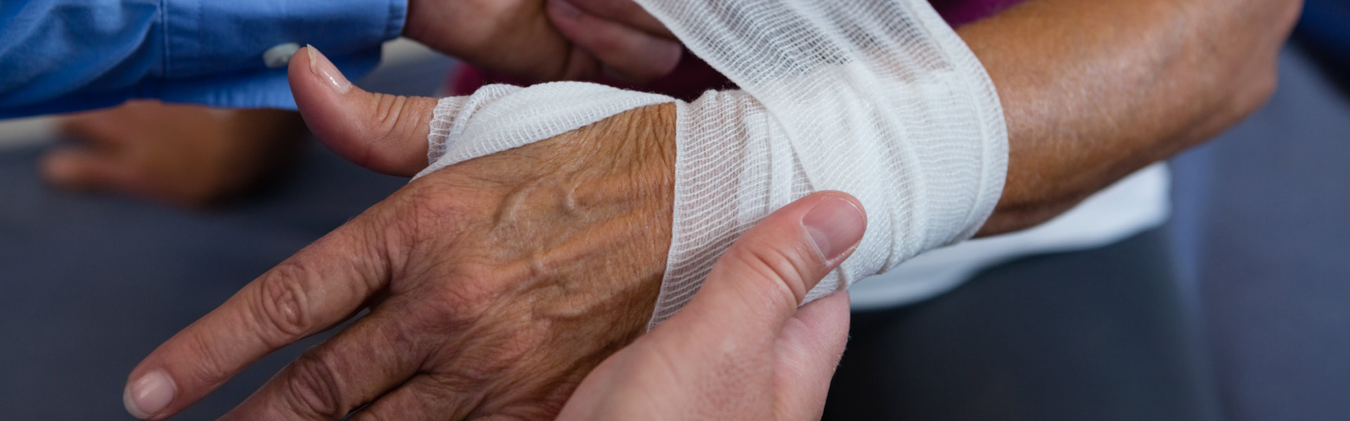 caregiver bandaging hand of patient